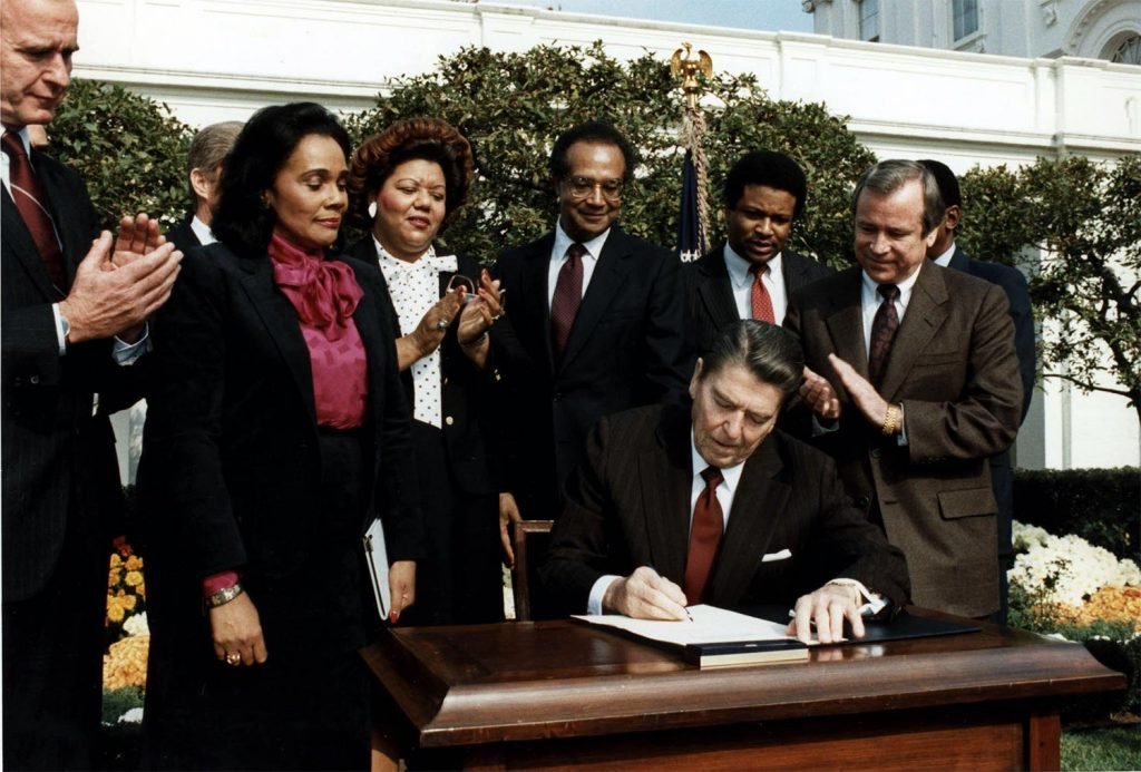 Ronald Reagan y Coretta Scott King en la ceremonia de firma de oficialización del Día de Martin Luther King Jr.